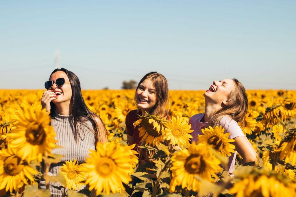 Three happy girls in sunflower field