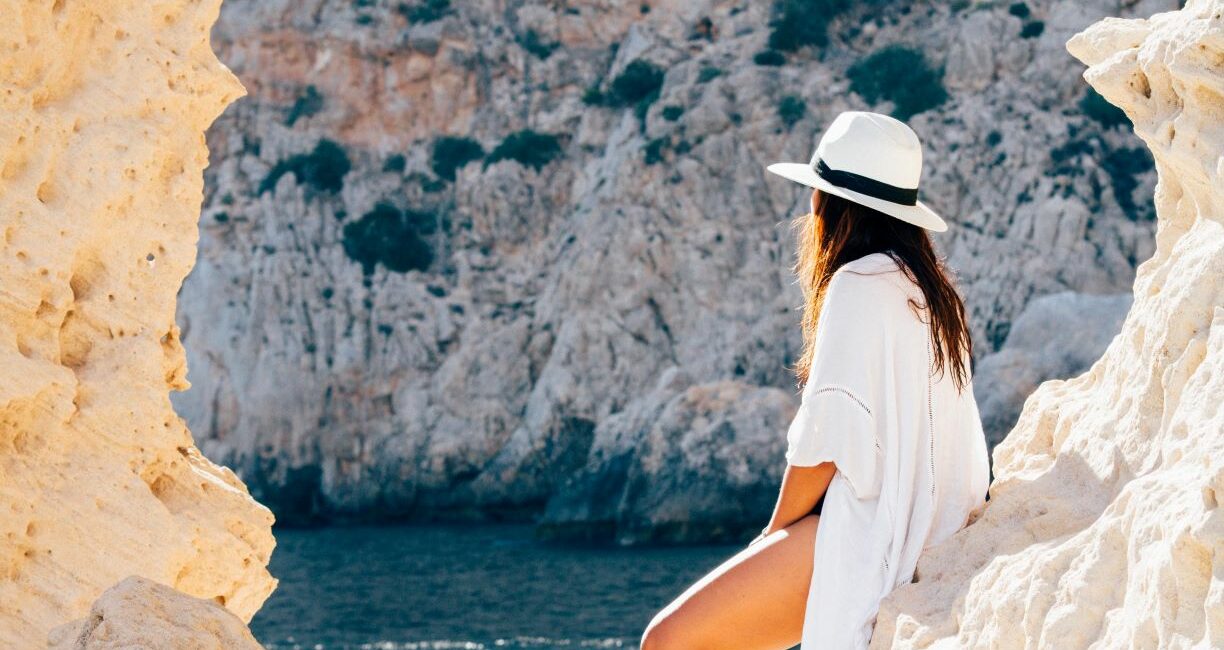 Girl in sustainable summer dress overlooking sea